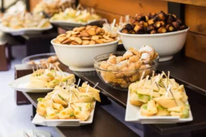 coffee break catering business conference wood brown tables full different snacks party white plates cheese 77607281