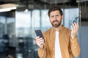 confused man holding phone receiving bad news young office his smartphone showing frustrated worried expression 404984821