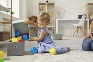 cute little year old child putting toys back their place helping mommy to tidy up little helper cleaning up learning to be 203439372