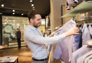 happy young man choosing clothes clothing store sale shopping fashion style people concept shirt jacket mall 75340783