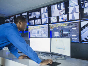 black security officer watching surveillance cameras BLEF07133