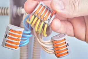 connections electrical wire pluggable connectors electrician holding wires spliced inside home junction box wiring 140980943