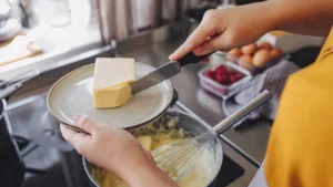 person cooking with butter lead